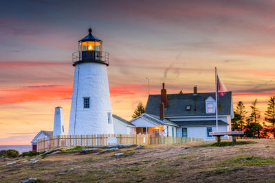 Lighthouse by sea against sky