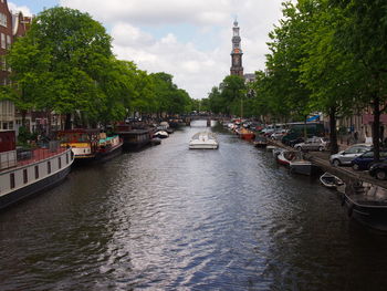 Boats in canal amidst buildings in city