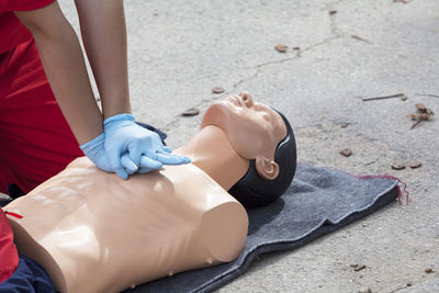 Midsection of paramedic performing cpr on mannequin