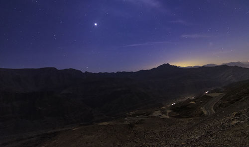 Scenic view of mountains against sky at night