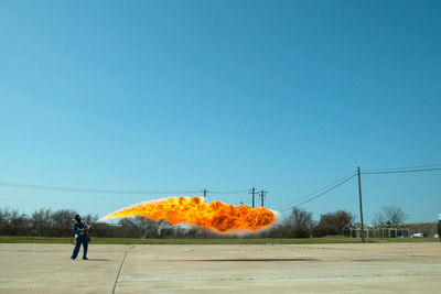Rear view of man standing on land against clear sky