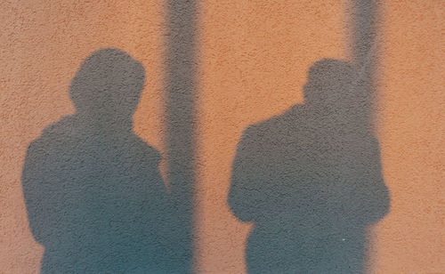 Shadow silhouette of young couple on the wall during sunset.
