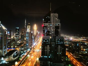 High angle view of illuminated city street and buildings at night