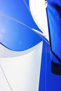 Low angle view of sailboat against blue sky