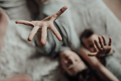 High angle view of hands on bed