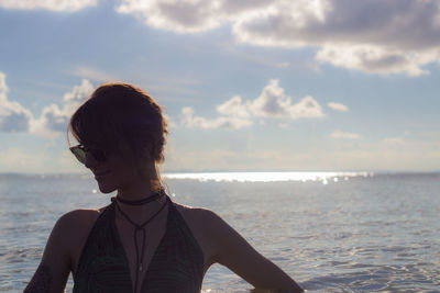 Young woman swimming in sea against sky