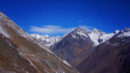 Scenic view of snowcapped mountains against blue sky