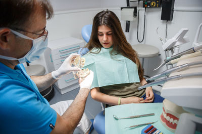 Male dentist with female patient in clinic