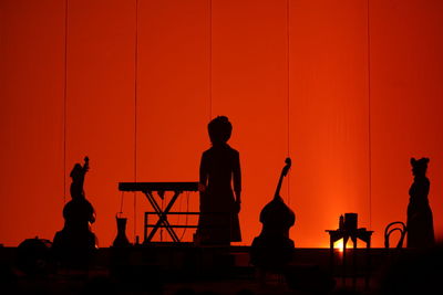 Silhouette people playing at music concert during sunset