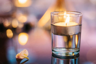 Close-up of burning candle on table