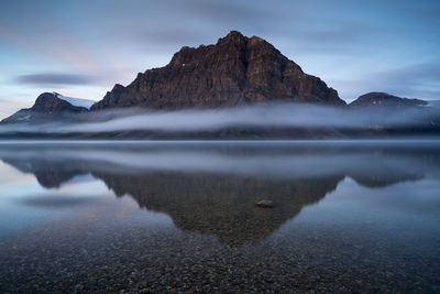Scenic view of rocky mountain and bow lake during sunrise