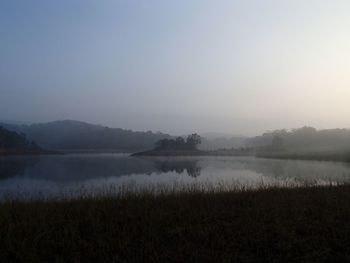Scenic view of lake against sky during foggy weather