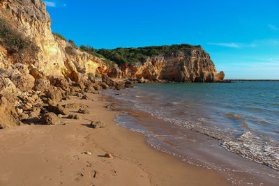 Rock formation on beach against sky