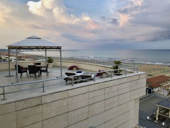 People in swimming pool by sea against sky