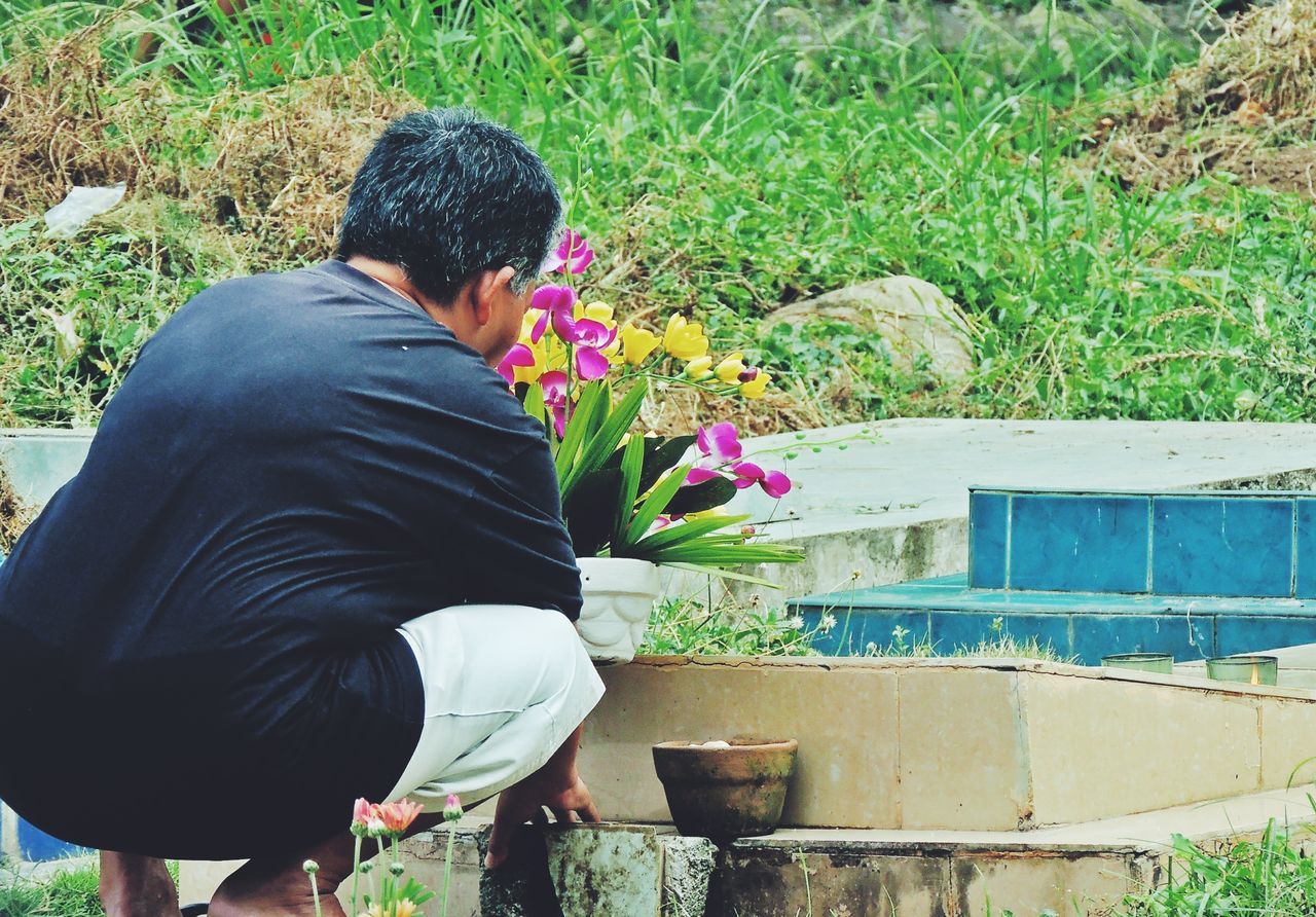 lifestyles, leisure activity, casual clothing, rear view, plant, standing, men, flower, holding, full length, three quarter length, growth, waist up, grass, day, field, nature