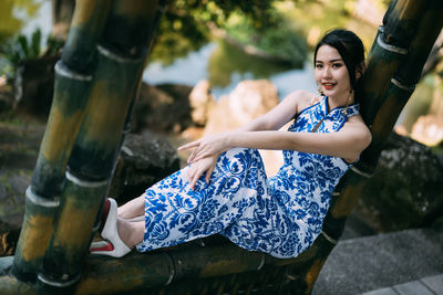 Low angle view of young woman sitting outdoors