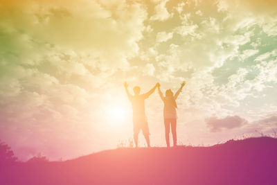 Friends standing against sky during sunset