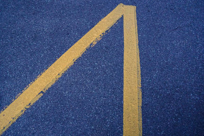 Close-up of yellow arrow symbol on road
