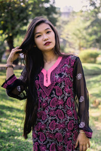 Portrait of beautiful young woman standing outdoors