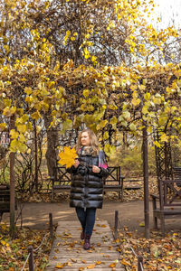 Portrait of a woman in a gazebo entwined with a vine in an autumn park.