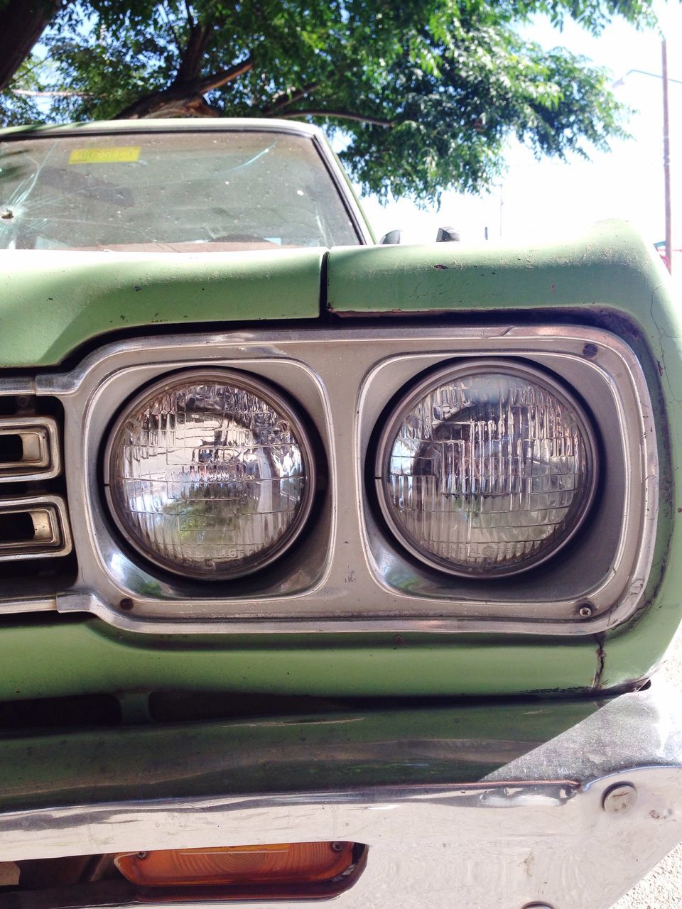 car, land vehicle, transportation, mode of transport, headlight, old-fashioned, street, retro styled, vintage car, reflection, part of, close-up, side-view mirror, tree, stationary, day, travel, road, no people, outdoors