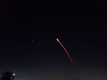 Low angle view of vapor trails in sky at night