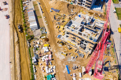 Aerial view of tower lifting crane and concrete frame of tall apartment residential building under 