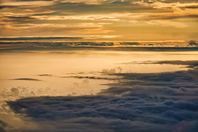 Scenic view of sea against dramatic sky during sunset