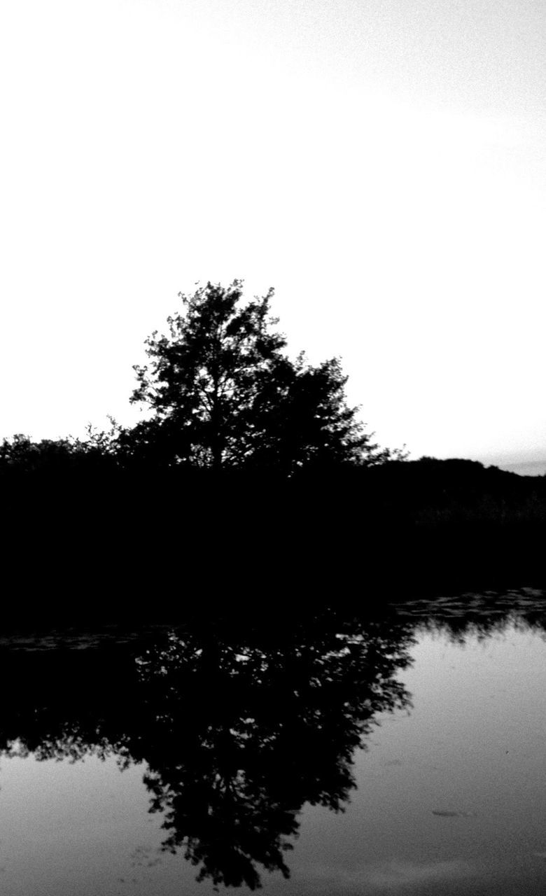 water, reflection, tranquil scene, tranquility, lake, tree, clear sky, silhouette, waterfront, scenics, beauty in nature, nature, copy space, standing water, idyllic, sky, calm, river, growth, sunset