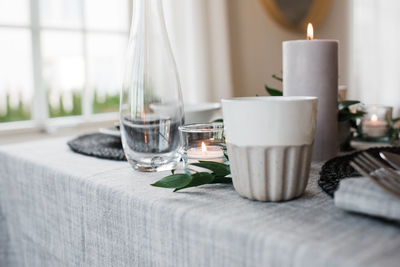 Water glass and candle on a romantic dinner table for two