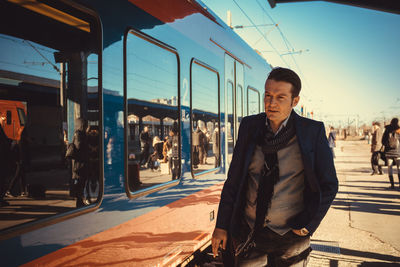 Portrait of man standing by train