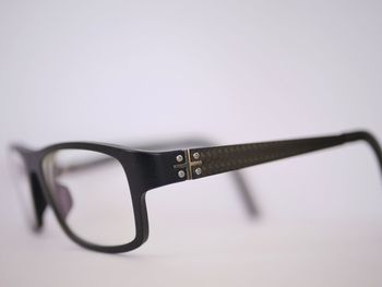 Close-up of eyeglasses on table against white background