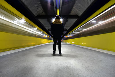 Rear view of man standing at subway station