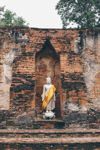 Statue of buddha against building