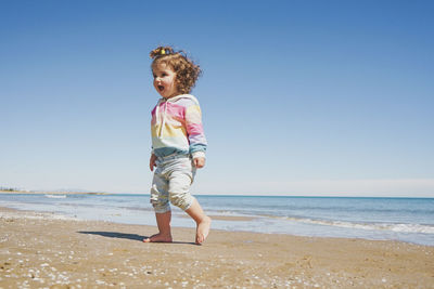 Full length of boy standing at beach