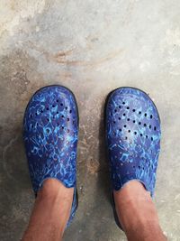 Low section of man standing against blue wall