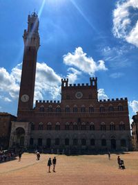 People at historic building against sky