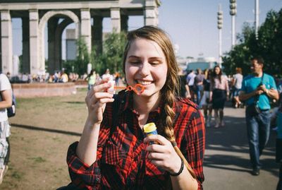 Happy teenage girl blowing bubbles outdoors