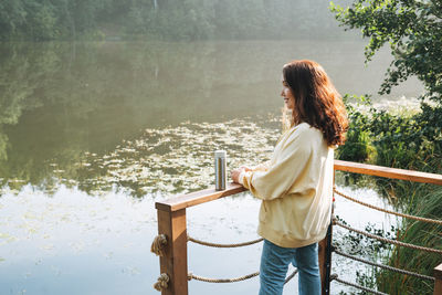 Rear view of woman standing by railing