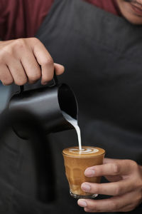 Midsection of man pouring coffee in cup