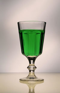 Close-up of wineglass on table against white background