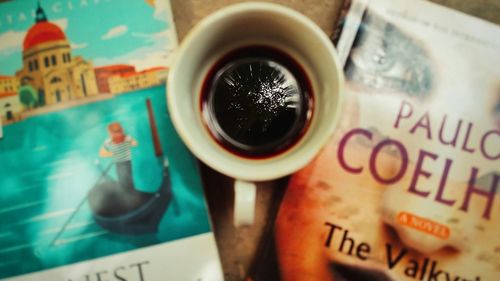 High angle view of coffee cup on paper