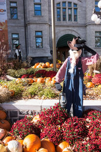 Full length of woman standing by flowering plants