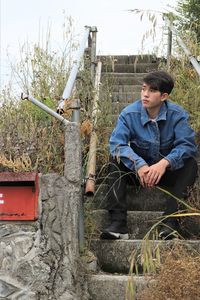 Portrait of man sitting on steps at house entrance