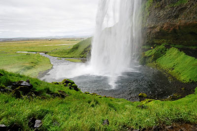 Scenic view of waterfall against sky