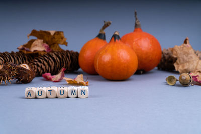 Close-up of pumpkins on table against orange background