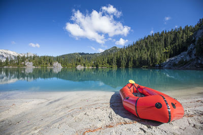 Paddle board on beach of remote mountain lake.