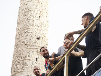 Low angle view of people against built structure