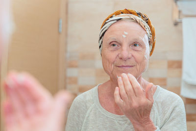 Elderly woman taking care of her face