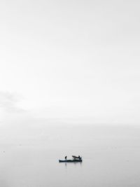 Fishing boat in sea against sky